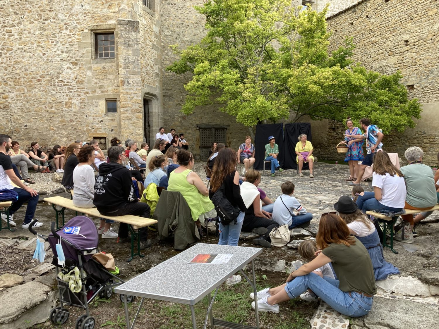 dans un cadre extérieur, devant un public estival, la troupe joue son spectacle